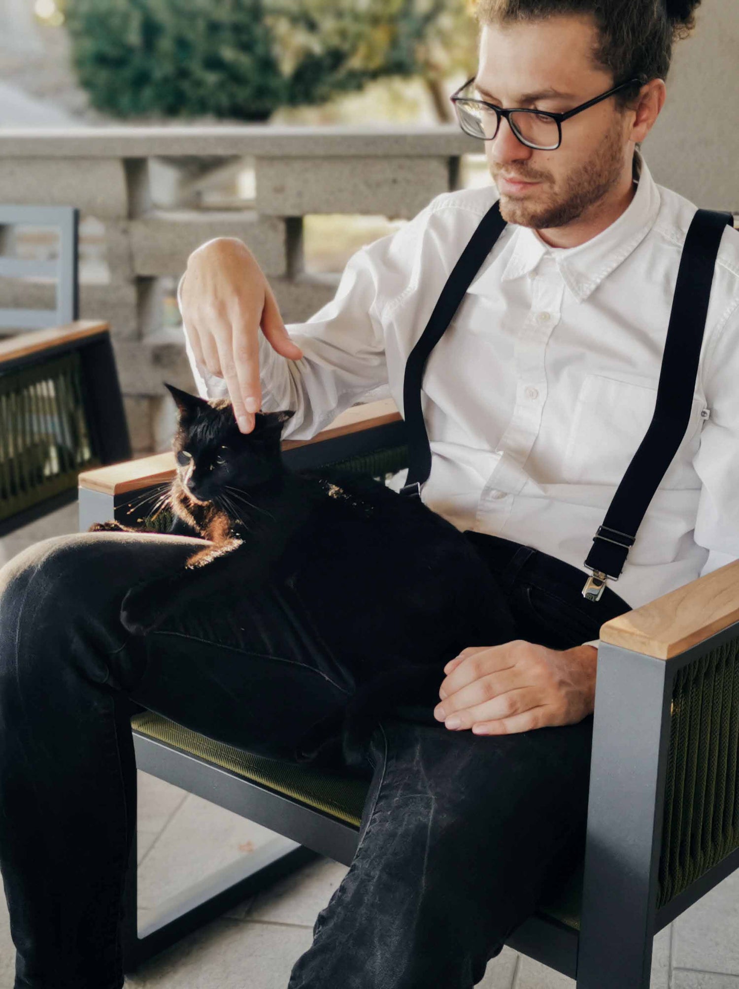 Riccardo Bacocco, fondatore di Bacocco Pet Couture, che trascorre un momento di tranquillità con il suo gatto nero